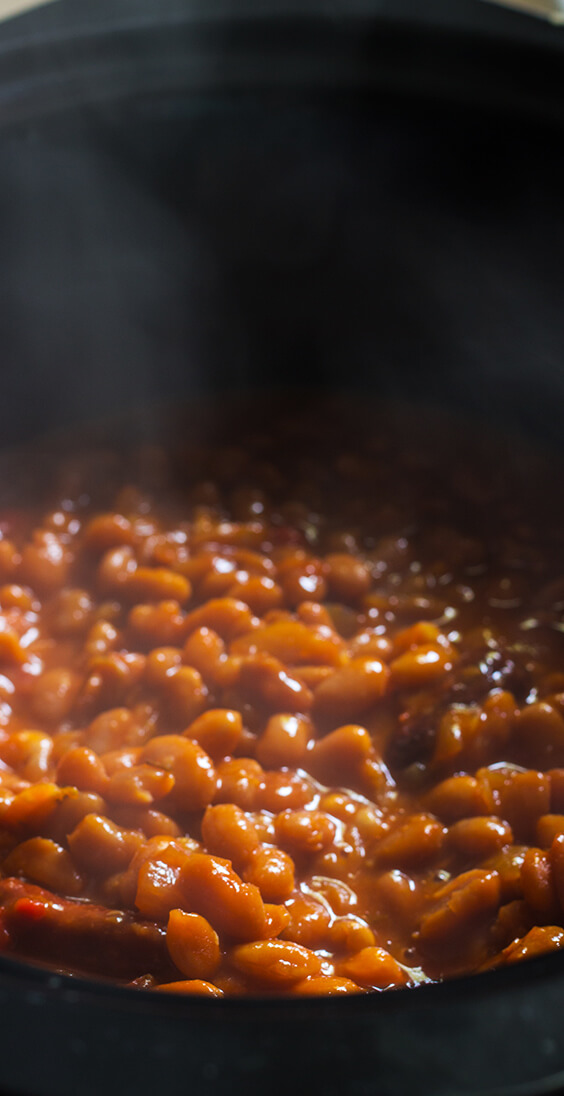 Just five basic ingredients: sausages, navy beans, molasses, sriracha and mustard. Super easy recipe for the best baked beans ever. make it today.