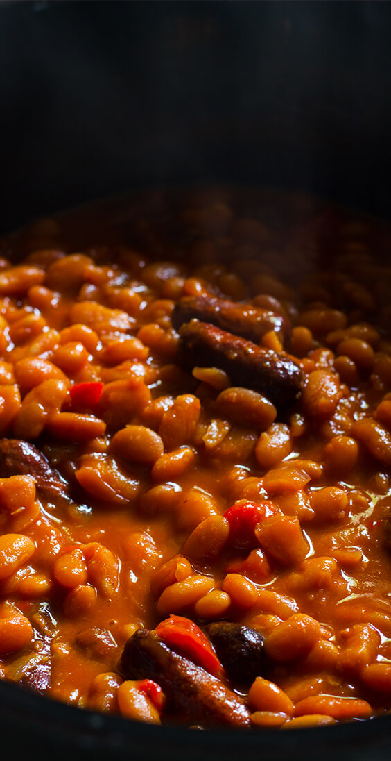 Just five basic ingredients: sausages, navy beans, molasses, sriracha and mustard. Super easy recipe for the best baked beans ever. make it today.