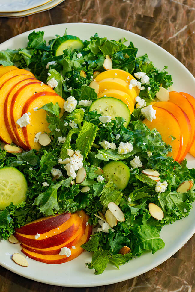 This peach goat cheese kale salad showcases ripe peaches, tangy goat cheese and crunchy almonds with a delicious balsamic vinegar dressing.