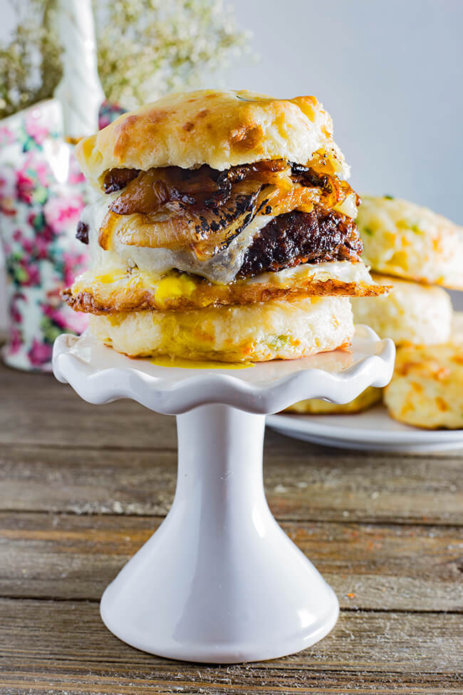 This Cheddar Steak Egg & Cheese Biscuit Sandwich is the perfect breakfast sandwich to start your day or the perfect breakfast for dinner option. A mouthwatering country-fried steak on a freshly baked, scratch-made biscuit topped with a crispy fried runny egg and spicy caramelized onion.