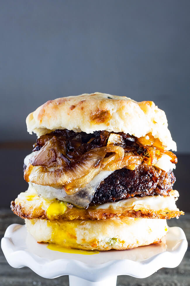 This Cheddar Steak Egg & Cheese Biscuit Sandwich is the perfect breakfast sandwich to start your day or the perfect breakfast for dinner option. A mouthwatering country-fried steak on a freshly baked, scratch-made biscuit topped with a crispy fried runny egg and spicy caramelized onion.